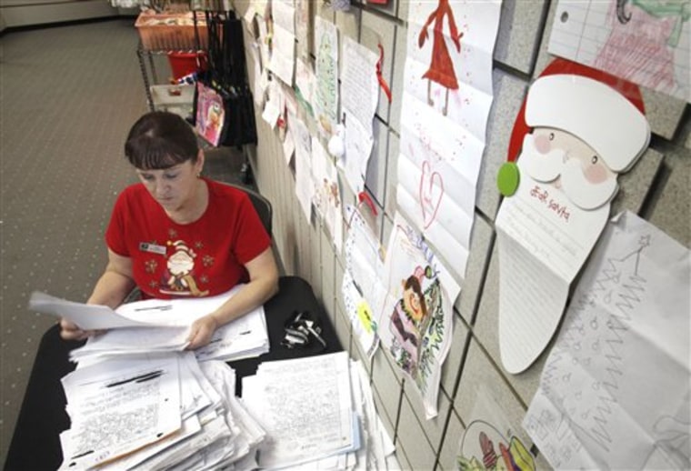 U. S. Postal Service employee Rita Rose looks a some of thousands of Dear Santa letters that her office handles in Sacramento, Calif., Wednesday, Dec. 15, 2010. The letters are on display so the public can read them and donate gifts that the post office will deliver to the families. 